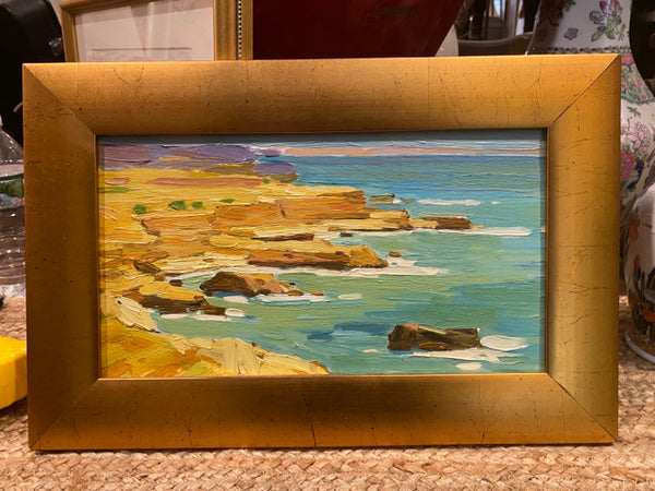 water scene painting in gold frame