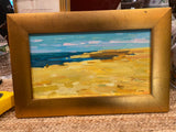 water scene painting in gold frame