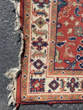 red rug with ivory border and blue and peach medallions