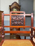 Carved caned open arm chair