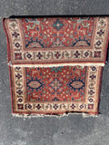 red rug with ivory border and blue and peach medallions