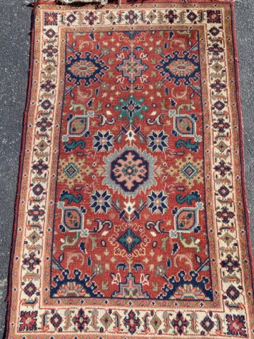 red rug with ivory border and blue and peach medallions