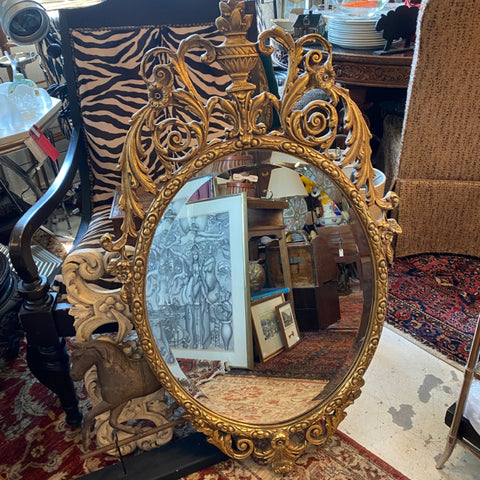oval shaped ornate gold framed mirror